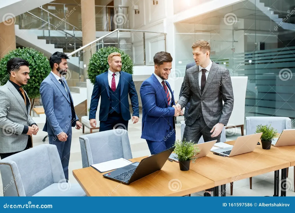 Partnerships & Collaborations business multi national group meeting shaking hands men suits laptop table background center office young leaders 161597586